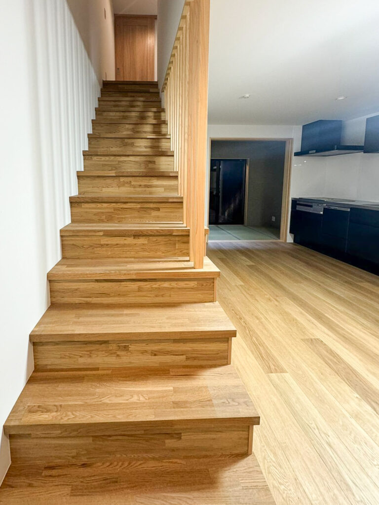 Renovated staircase with wooden steps leading to the upper floor of the Machiya